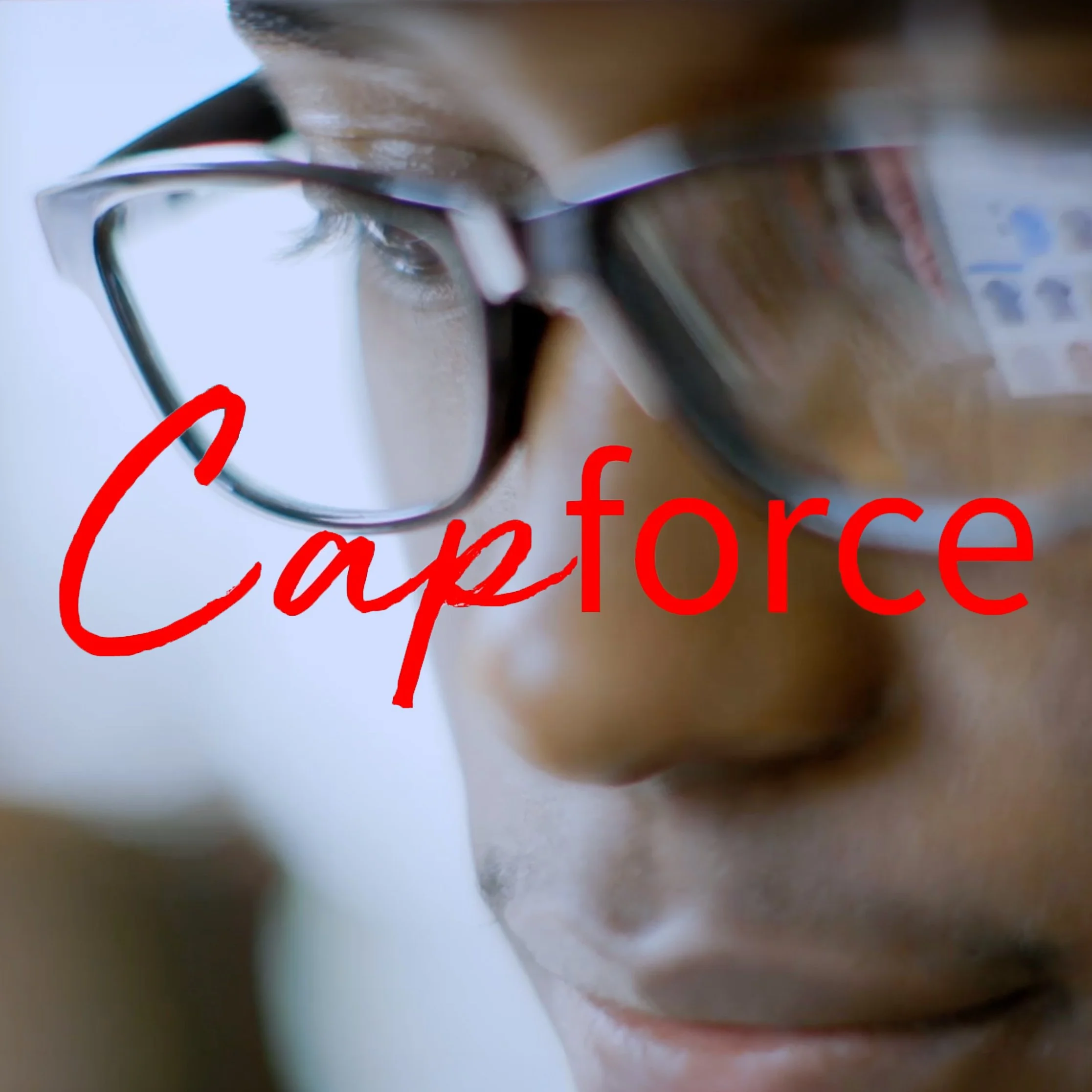 Close-up of a person wearing glasses with a focused expression, reflecting screen light. The word "Capforce" is in bold red across the image.