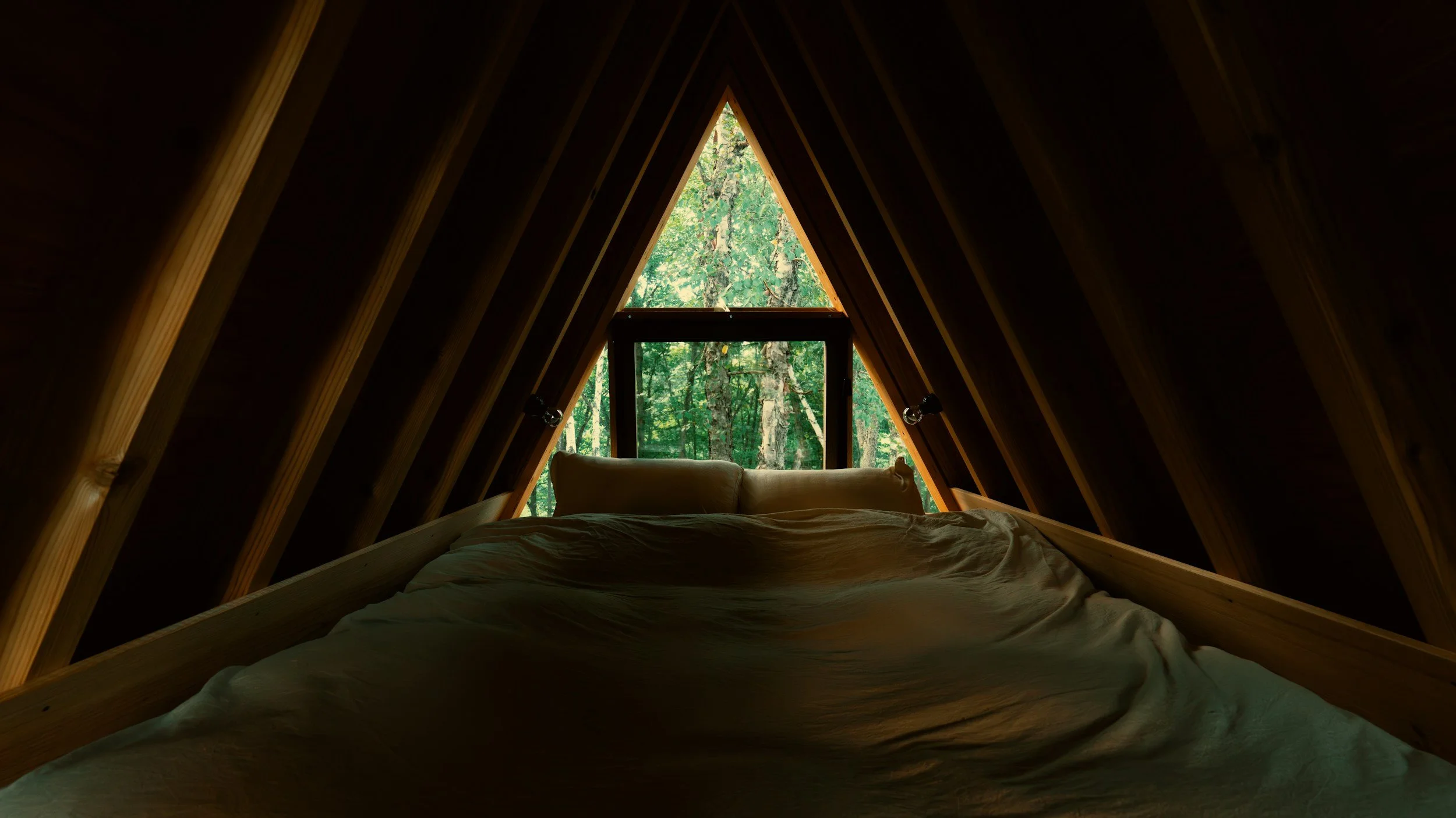 A-frame glamping structure with forest view illustrating outdoor hospitality development and site planning