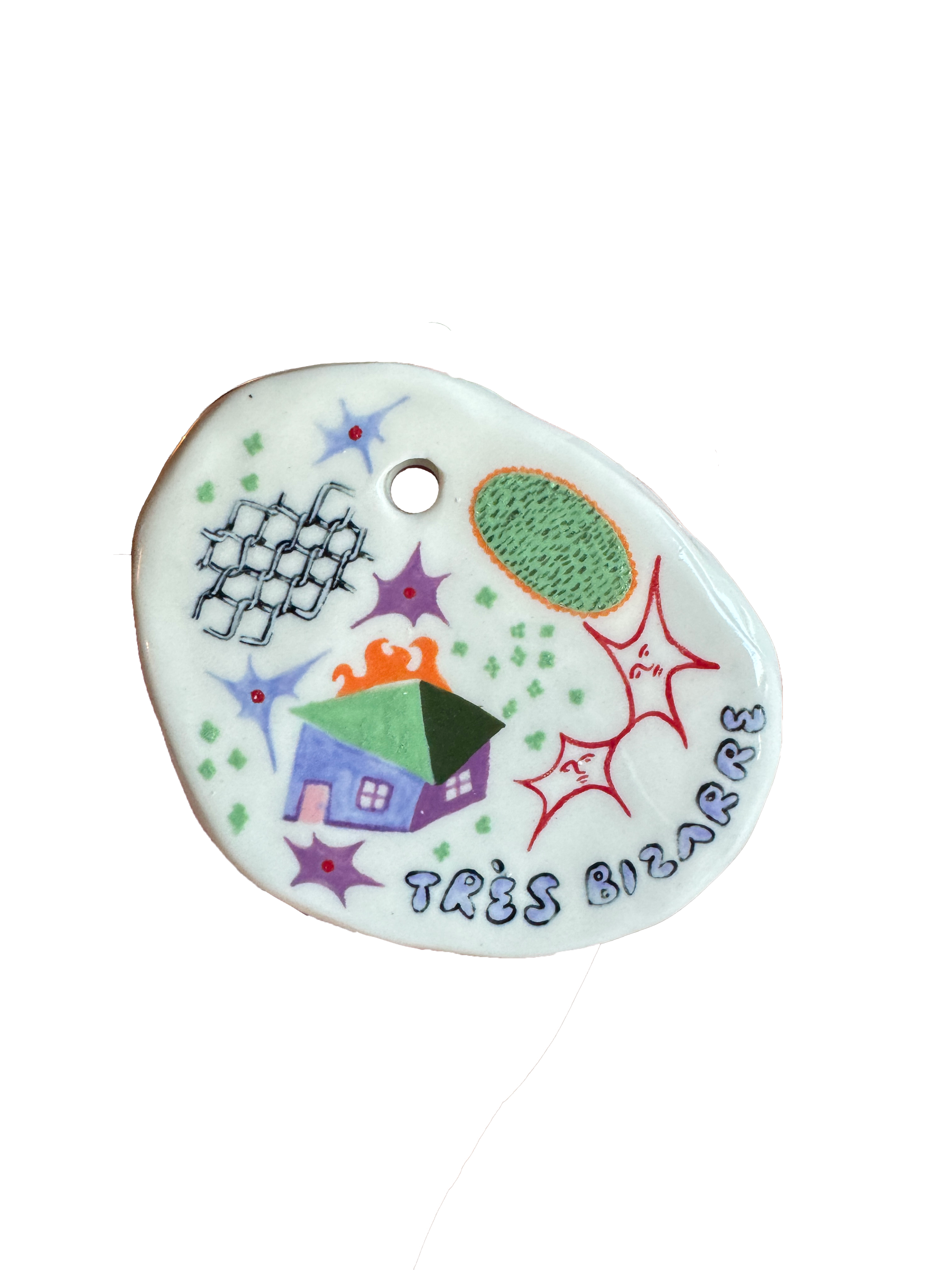 A ceramic object decorated with colorful drawings and words, including a house, an umbrella, and a variety of star and burst shapes, with the text "TRES BIZARRE".