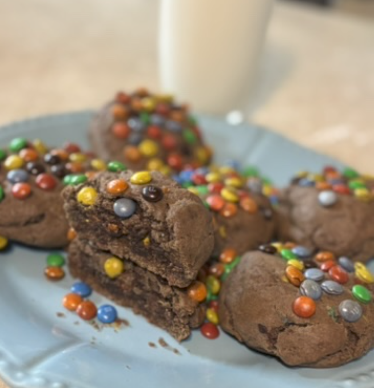 Chocolate brownies topped with colorful sprinkles on a light blue plate.