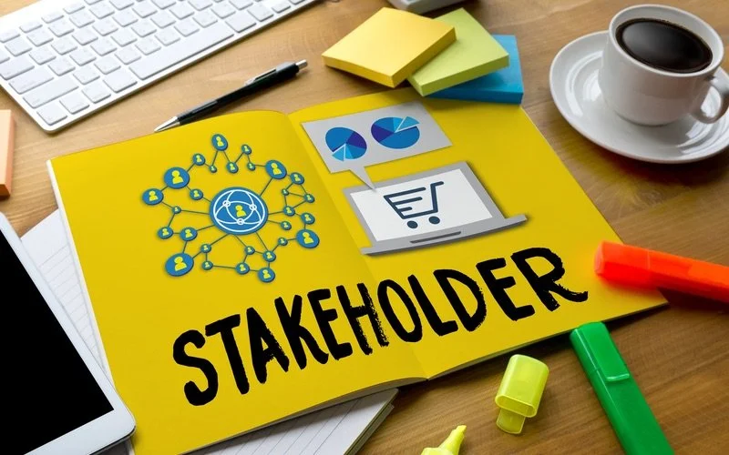 Desk scene with notebook that says "Stakeholder"