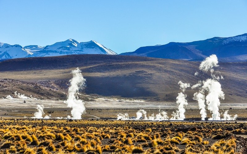 Mountain scene behind steam geysers