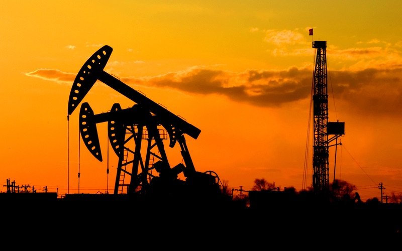 Oil rigs in front of an orange sky