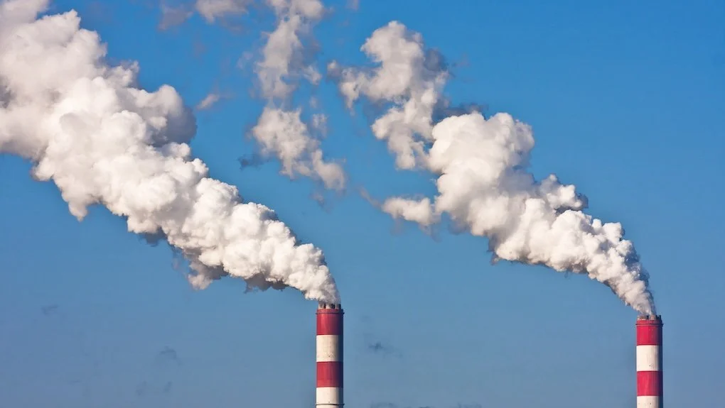 Two smoke stacks emitting gas