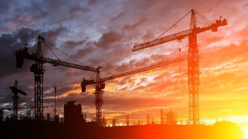 Cranes at a construction site with a pretty sky