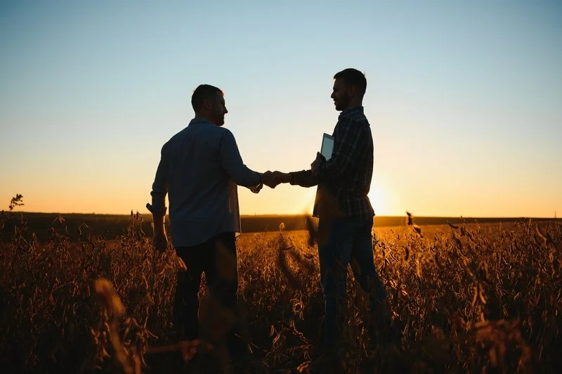 Two men shaking hands in a field