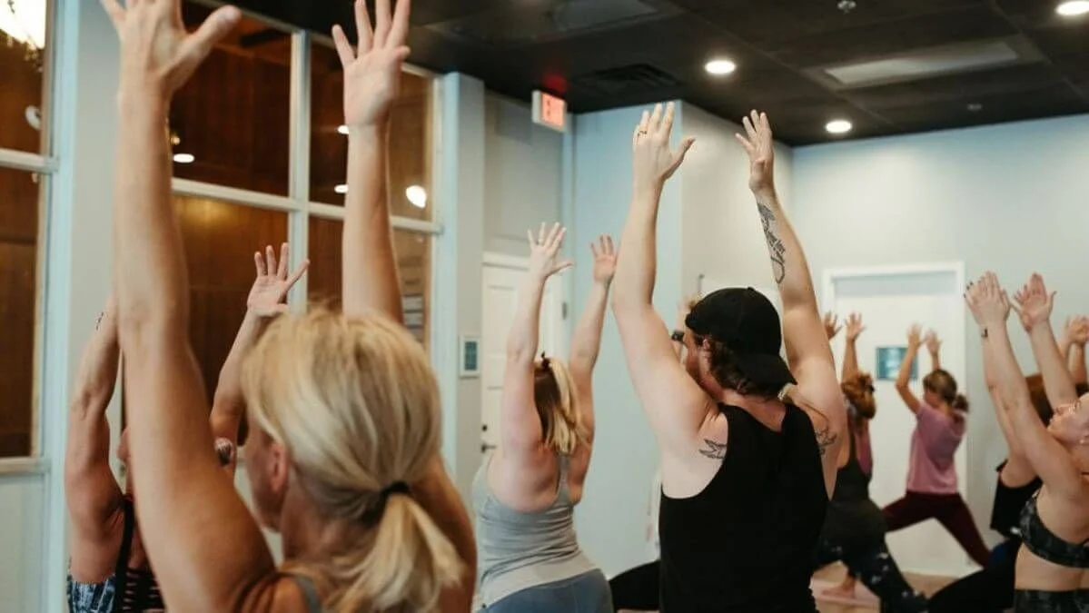 students in yoga anatomy school teacher training with arms up in air for vinyasa