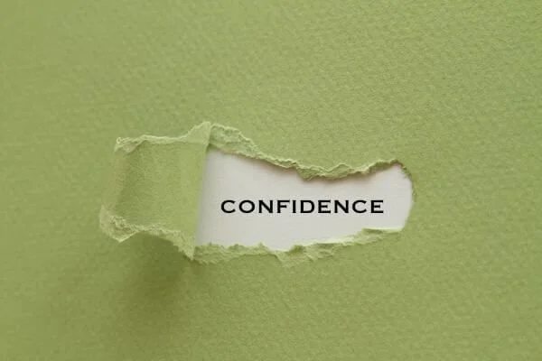 image of word confidence on other side of torn green paper