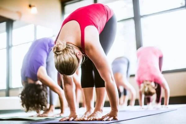yoga student with conscious breath in forward fold on mat