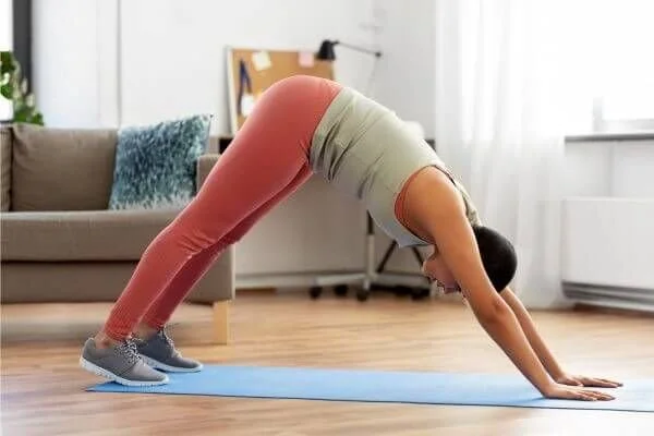 yoga student in downward facing dog with decreaswed lumbar lordosis