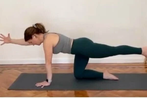 trish corley on yoga mat in bird dog demonstrating strong core with empowering cues