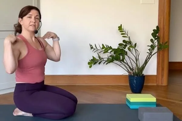 yoga teacher trainer trish teaching alignment of chaturanga and pointing to shoulders