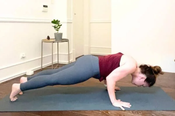 trish corley in chaturanga with head down on yoga mat
