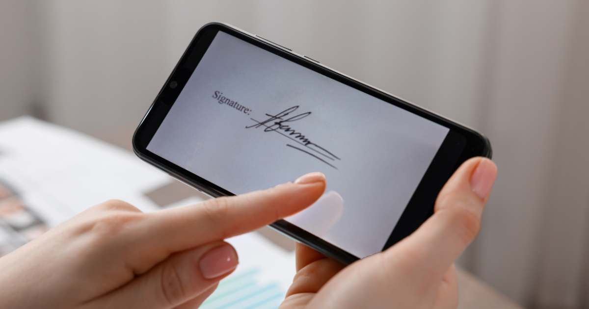 Person holding a smartphone with a digital signature on the screen