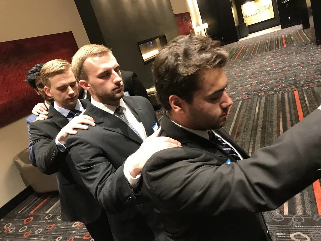 Undergraduates linked hand on shoulders