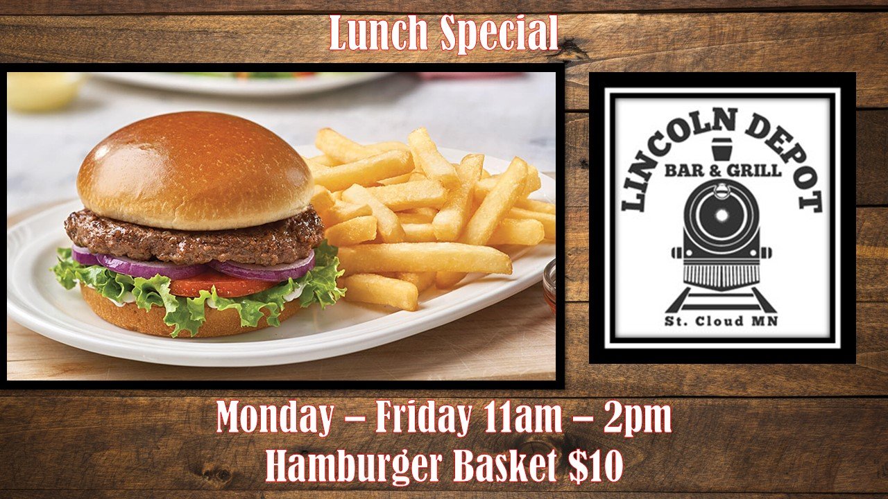 A hamburger with lettuce, tomato, onions, and a beef patty in a bun, served with French fries on a white plate. The background features a wooden surface and a sign for Lincoln Depot Bar & Grill in St. Cloud, MN, with lunch special details.