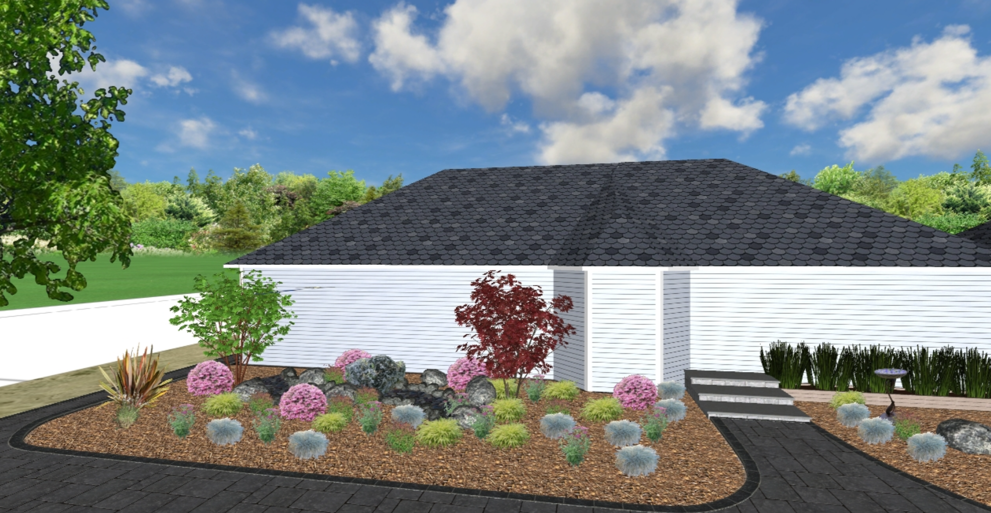 A landscaped backyard with a white fence, garden bed with colorful plants and rocks, a stone pathway, and a house with a dark shingle roof under a partly cloudy sky.