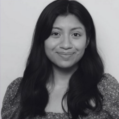 Black and white portrait of a young woman with long dark hair, smiling softly at the camera
