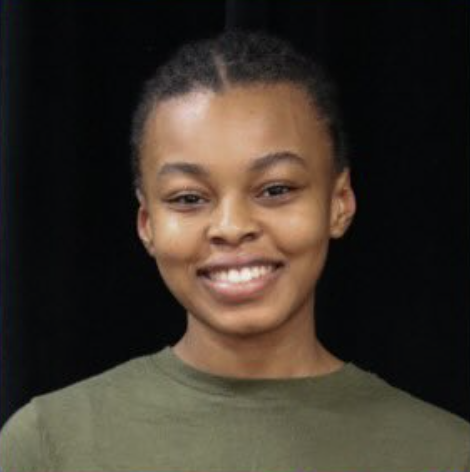Smiling young woman with braided hair wearing a green shirt against a black background.