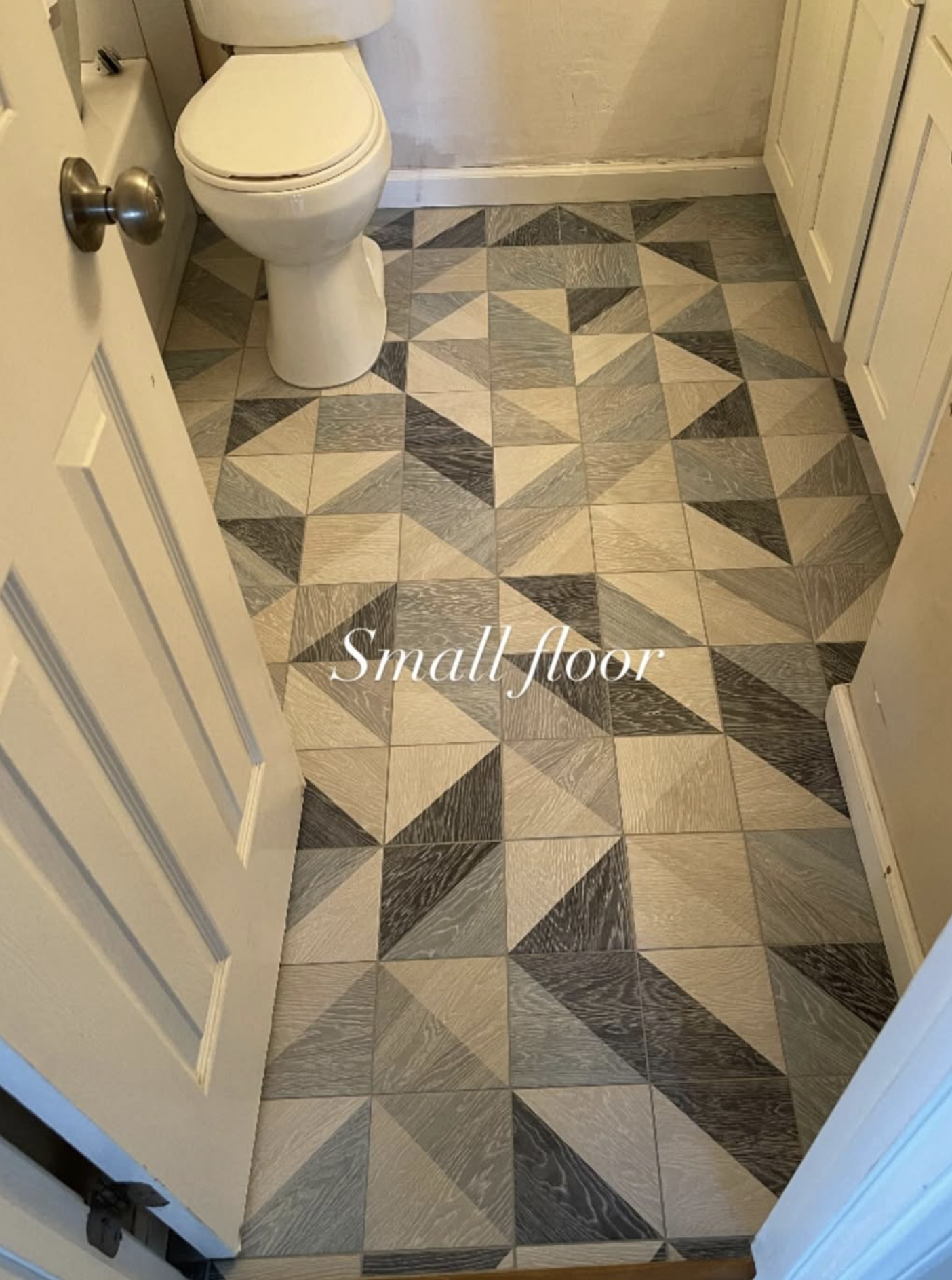 Small bathroom with geometric patterned tile floor and a toilet.