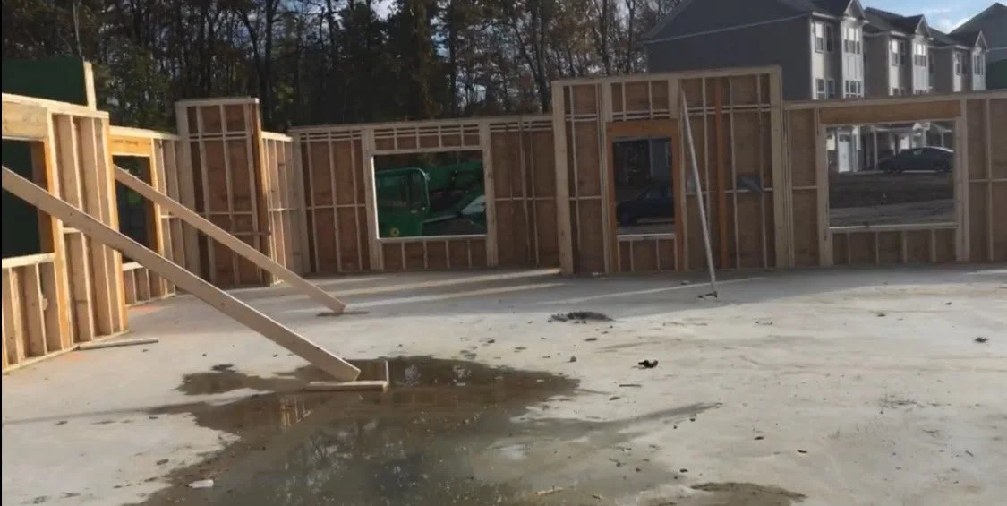 Construction site of a house, showing wooden framing, a concrete floor