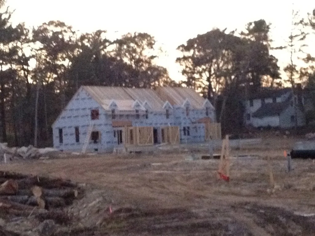 A house under construction with a metal roof in a developing neighborhood 