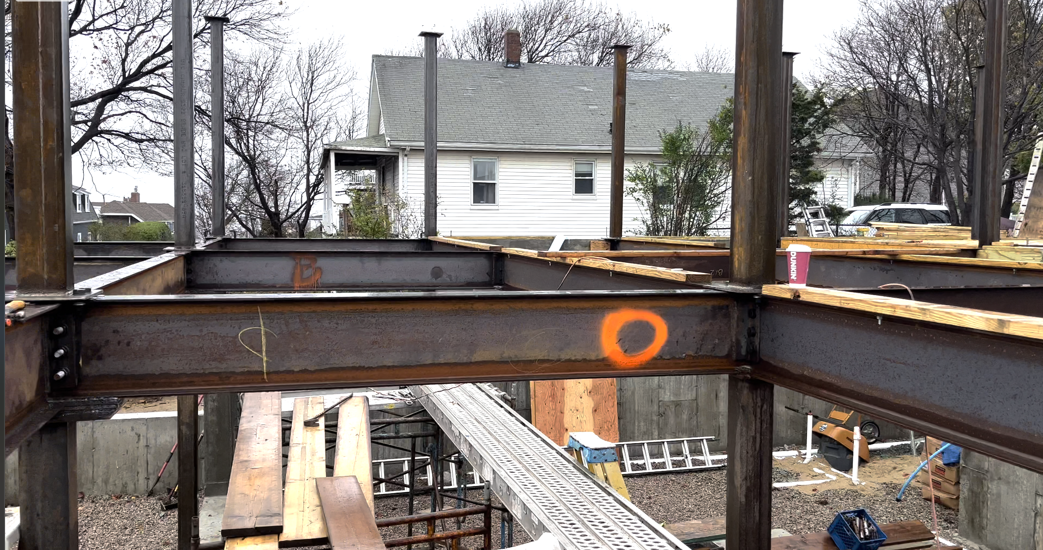 Construction site with steel beams, wooden planks, and scaffolding for building a house
