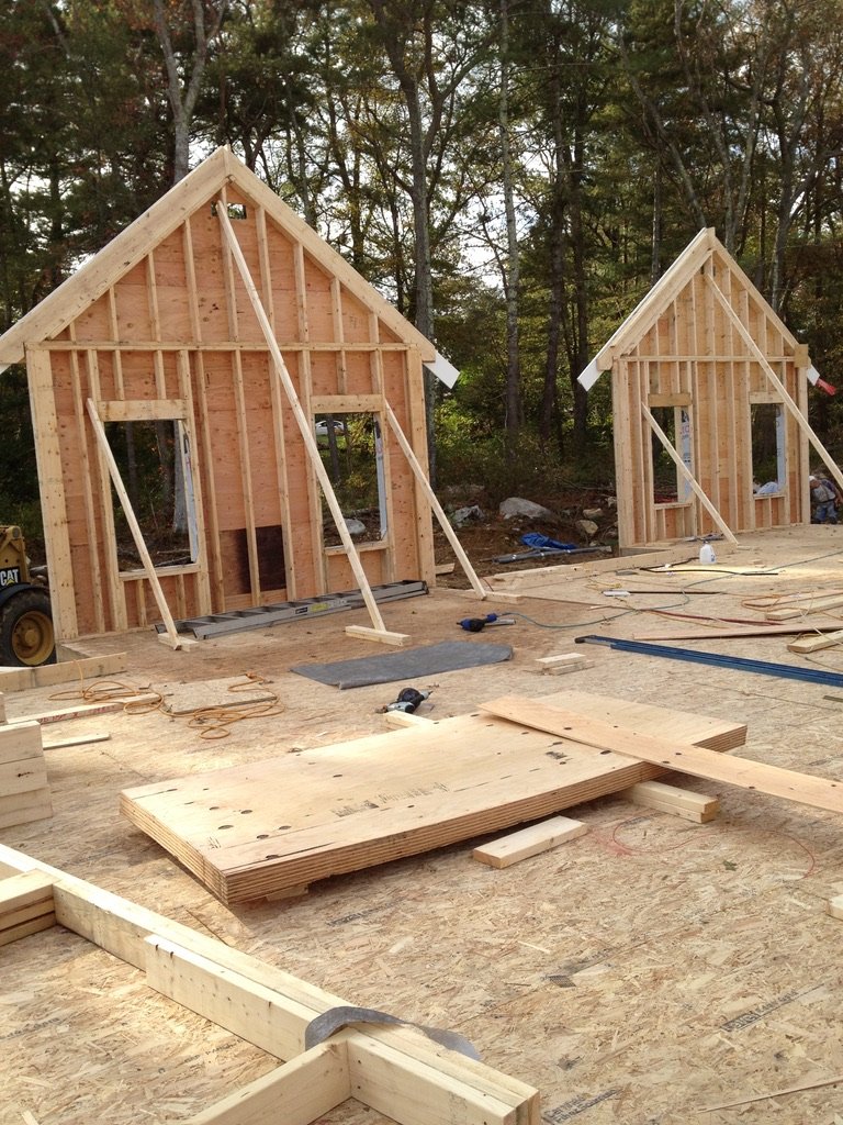Construction site with two partially built wooden small houses or sheds