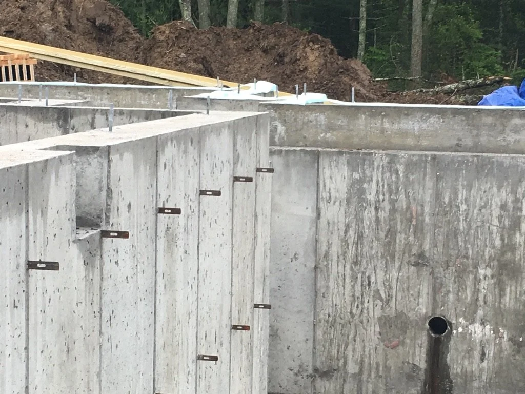 Construction site with concrete foundation and metal brackets,