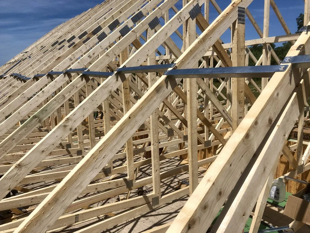 Wooden roof trusses under construction with metal connectors