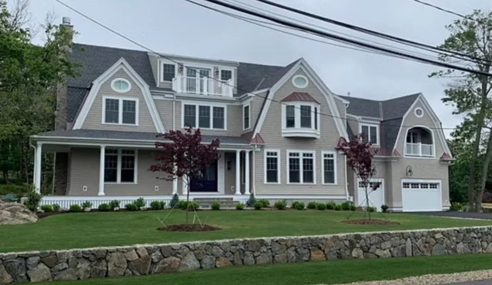 Large modern house  multiple gables, a front porch, and a garage