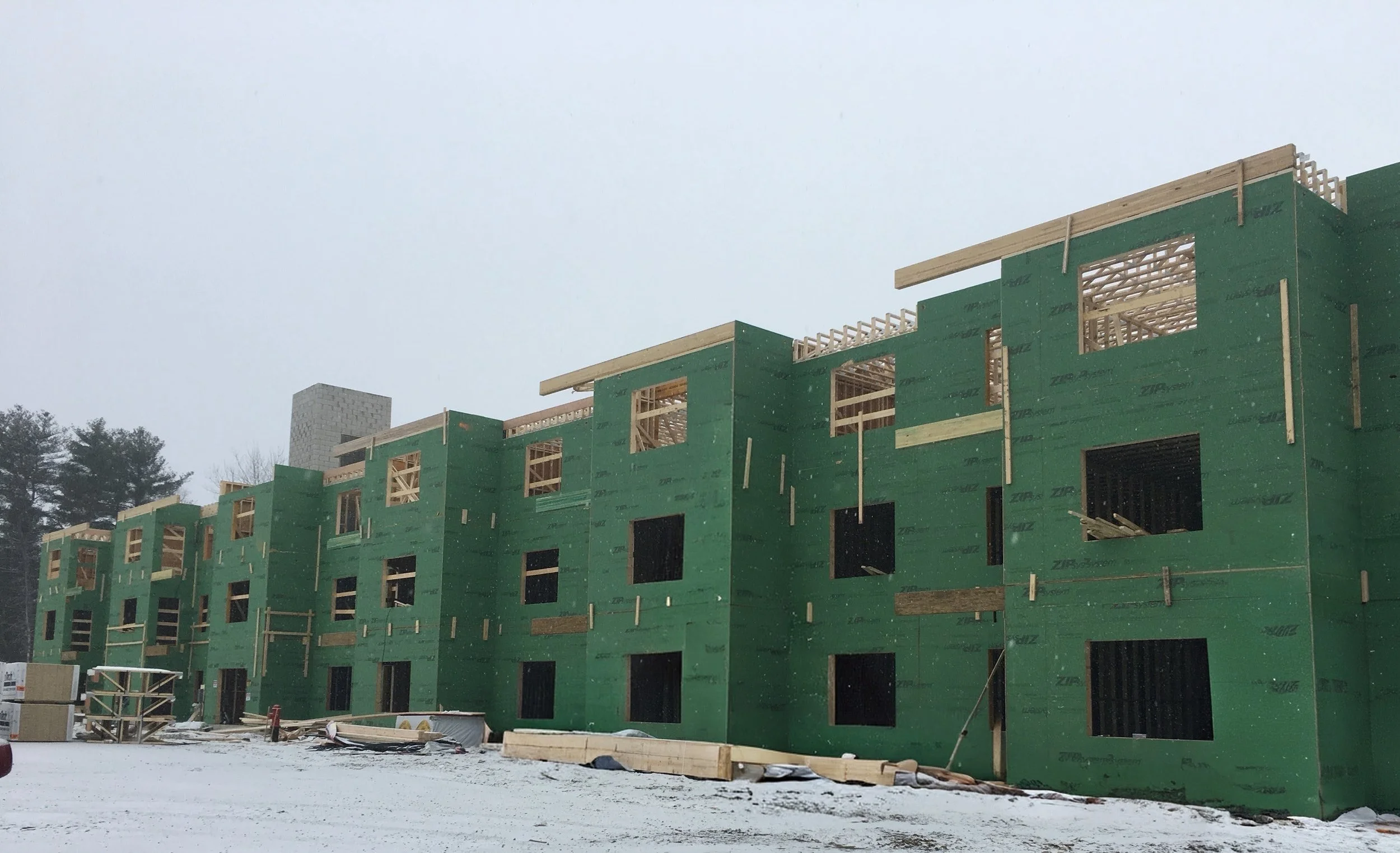 Under construction multi-story building with green sheathing