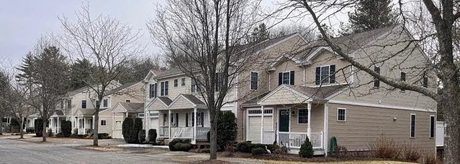 A row of beige and white houses with small front porches 