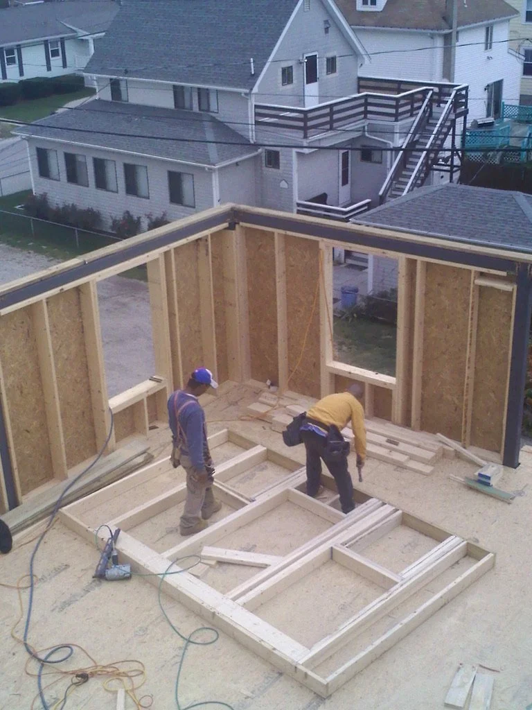 Construction workers building a wooden frame for a house.