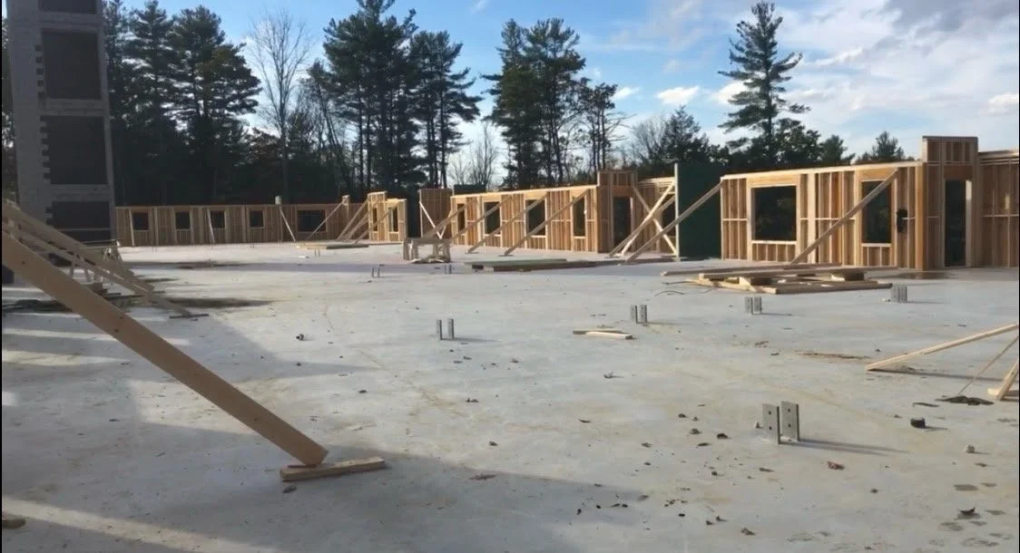 Construction site with unfinished wooden framing on a concrete foundation