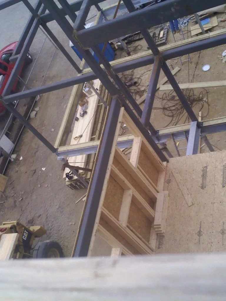 Construction site with metal framework and wooden structures in progress