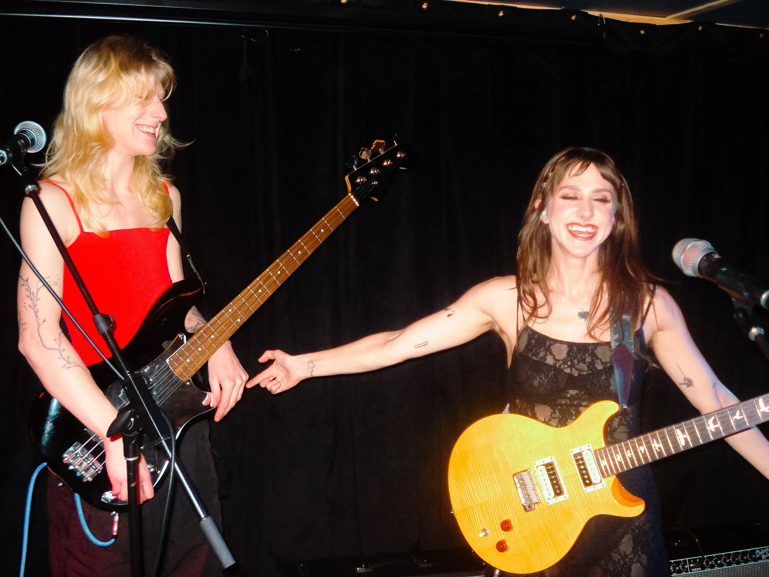 Stupid Lucky Live at Cassette in Ridgewood Queens, NYC - Photo by Beth Crane on Digital Camera. Taylor Pearlstein gestures to bassist Lotus Rogers.