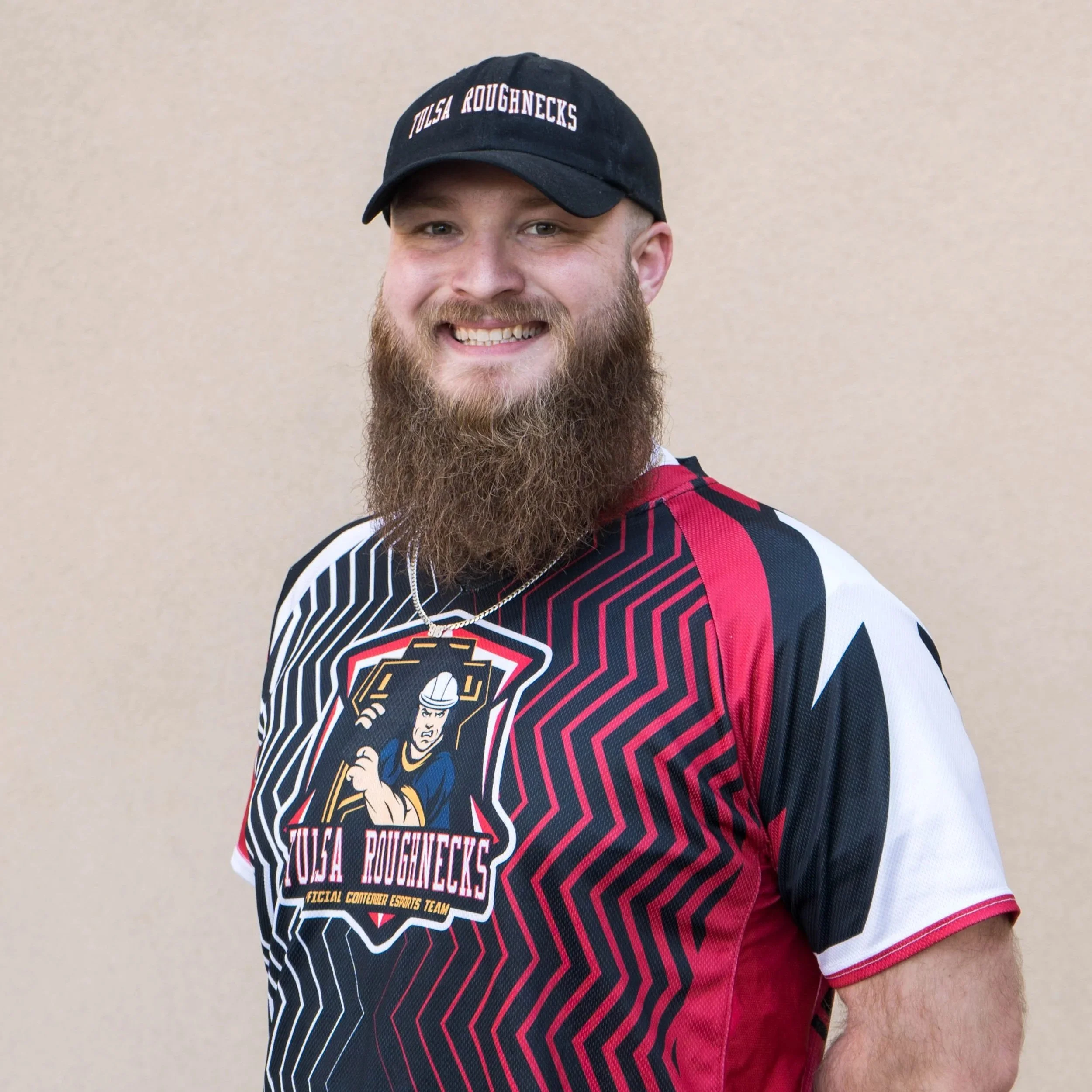 918 eSports Coach Destry smiling in a custom Tulsa Roughnecks jersey, providing lead mentorship and eSports strategy for the youth academy.