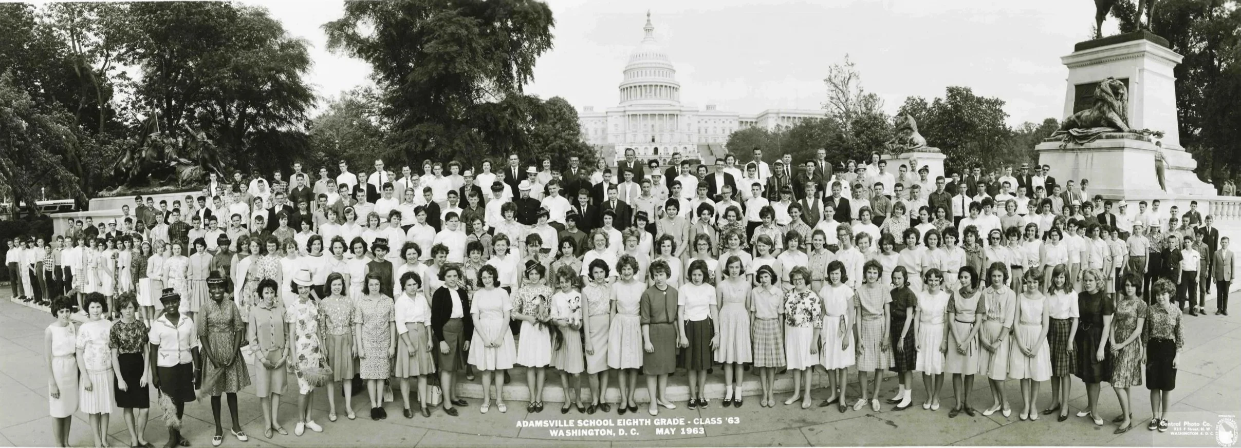 A large black-and-white photograph of a group of eighth-grade students and their teachers from Adamsville School, class of 1963, taken outdoors in Washington, D.C. with the Capitol building in the background. Central archival photograph.