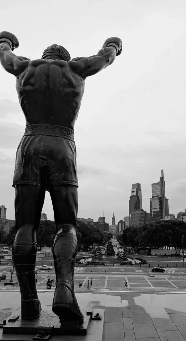 Rocky statue in front of the Philadelphia Museum of Art with city skyline in background