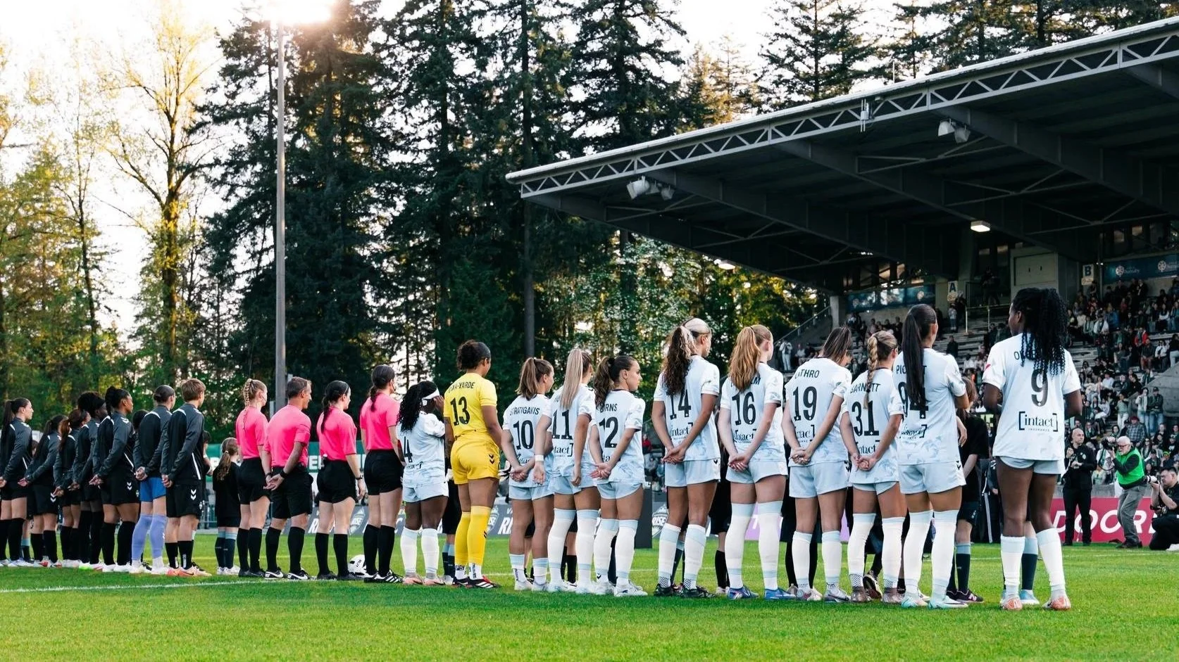 AFC Toronto and Vancouver Rise  players line up for the national anthem at Swangard Stadium