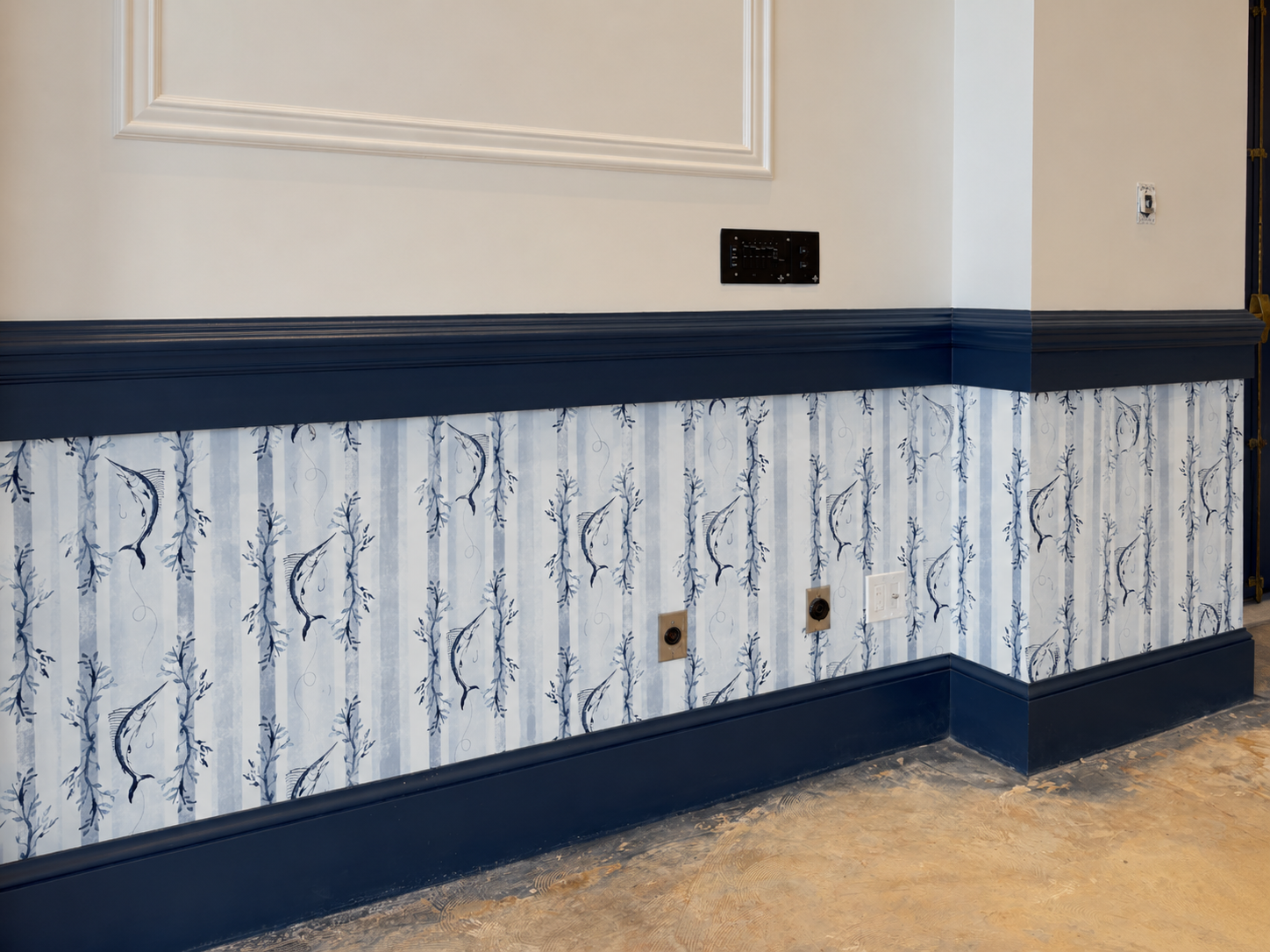 Interior wall with white and blue patterned wallpaper, dark blue wainscoting, and electrical outlets.