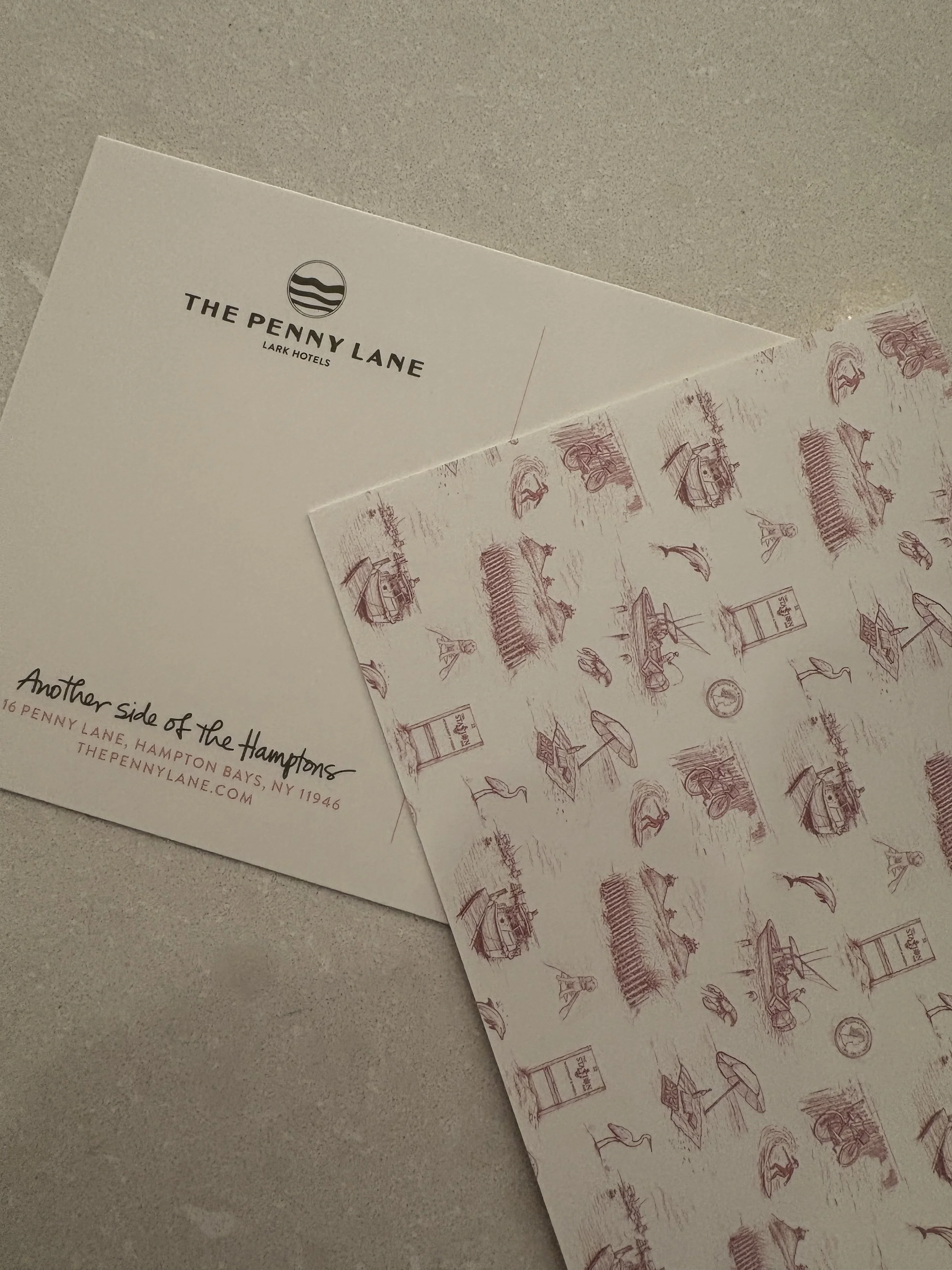 Close-up of printed papers with logo and illustrations, on a gray surface.