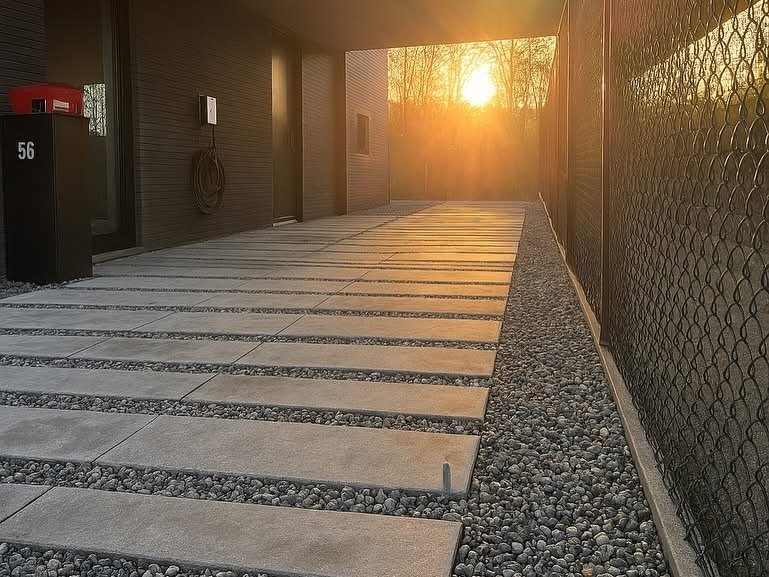 Een modern voorterrein met betonnen tegels en grind, gefilterd door de zonsondergang.