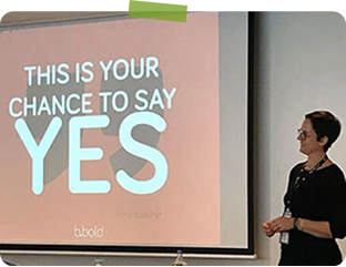 Woman giving a presentation with a slide that reads, 'This is your chance to say YES'.
