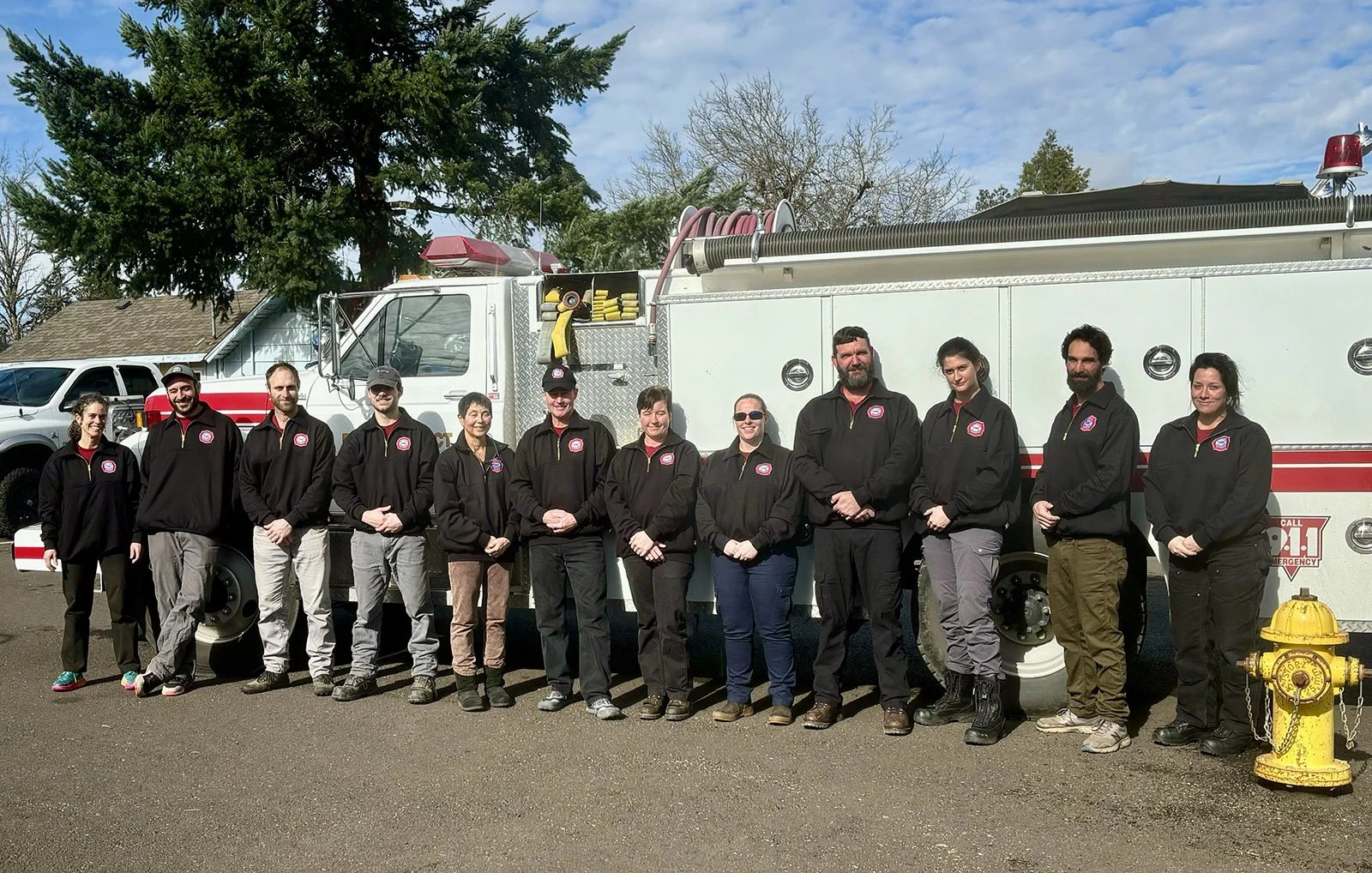 Group of people standing in front of a fire truck.