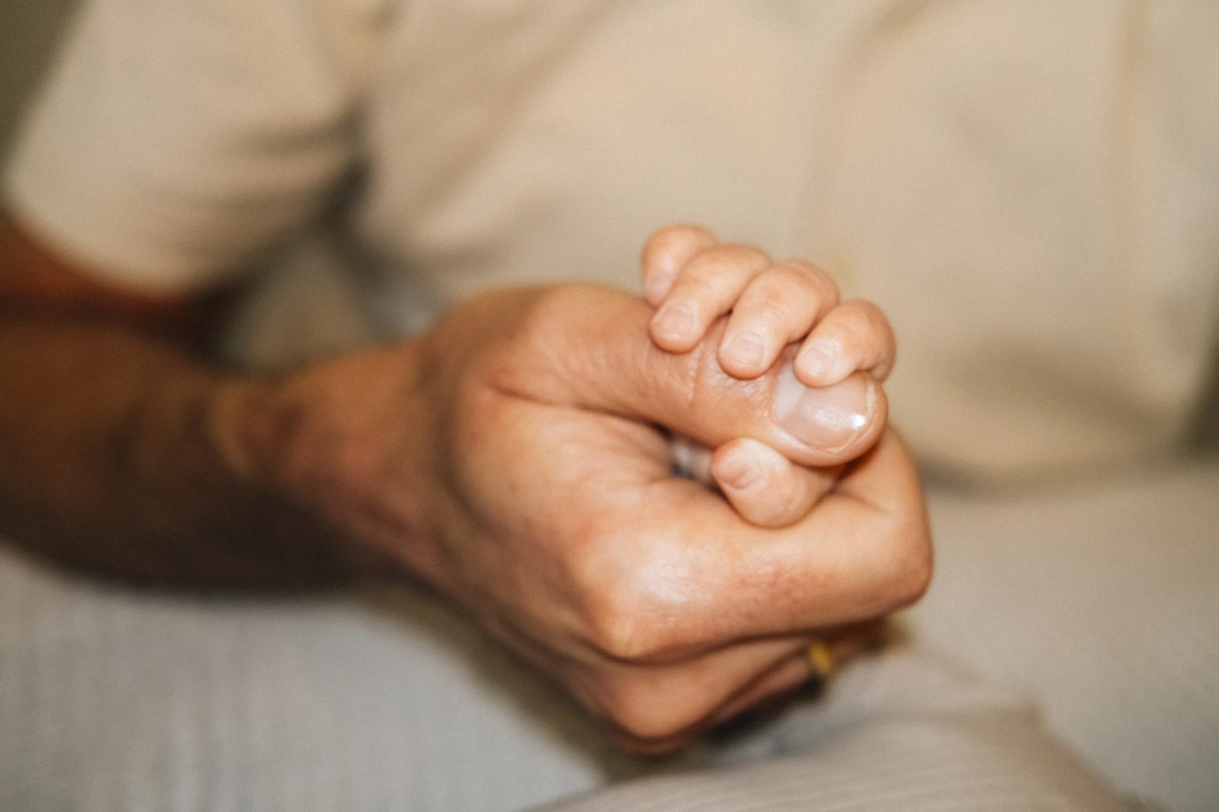 Nahaufnahme von den Händen eines älteren Menschen, mit einer Kinderhand.