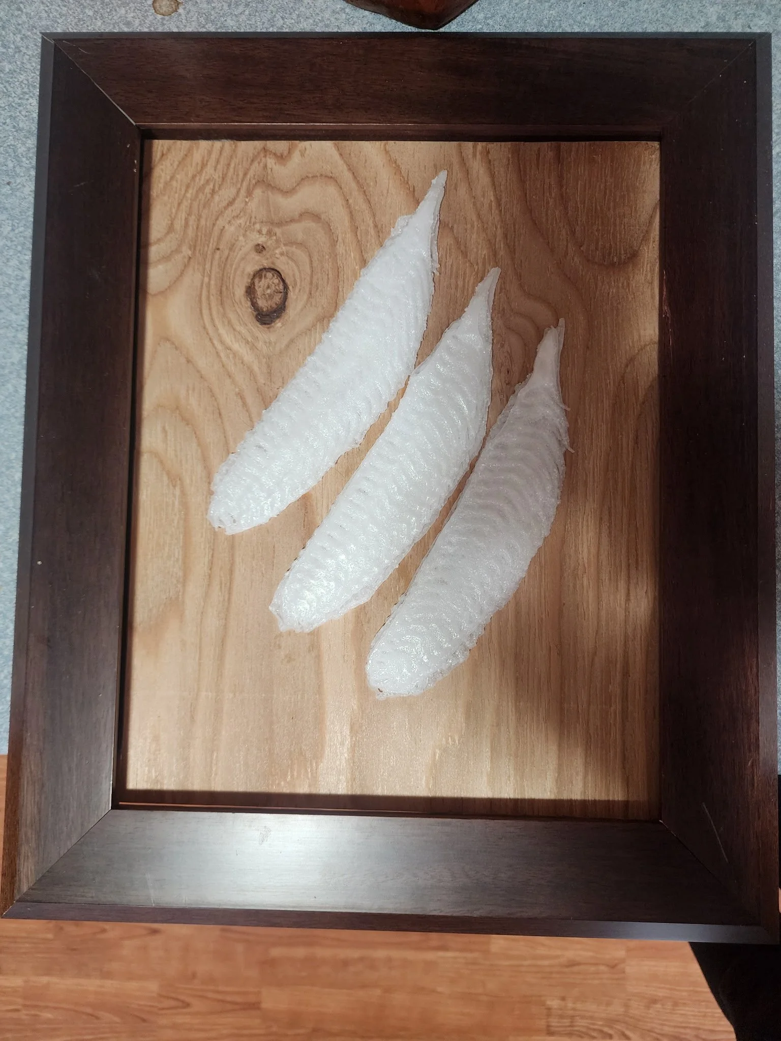 Three zongzi, traditional Chinese sticky rice dumplings, arranged on a wooden tray with a dark border.