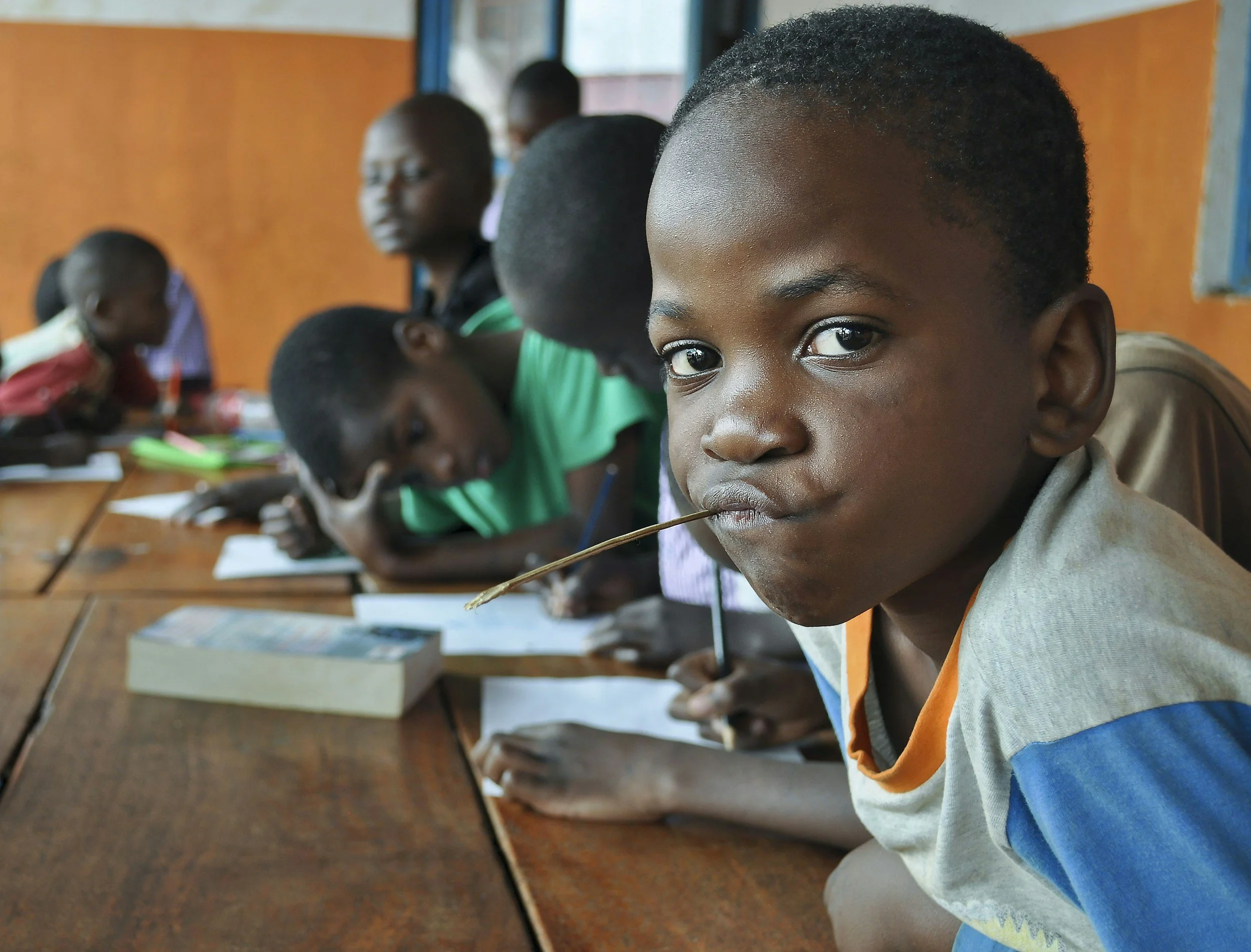 Children sitting at desks in a classroom, focusing on their work.