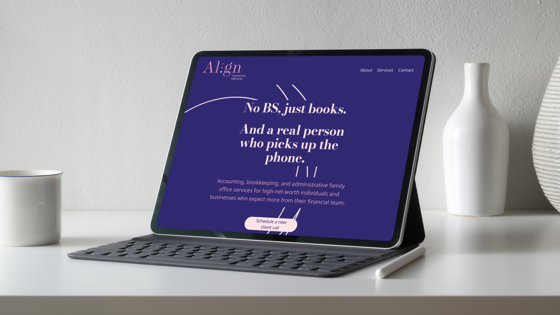 A tablet with a keyboard stands on a white desk, displaying a website for Align Financial Services with the headline 'No BS, just books. And a real person who picks up the phone.' There is a white coffee mug on the left and two vases.